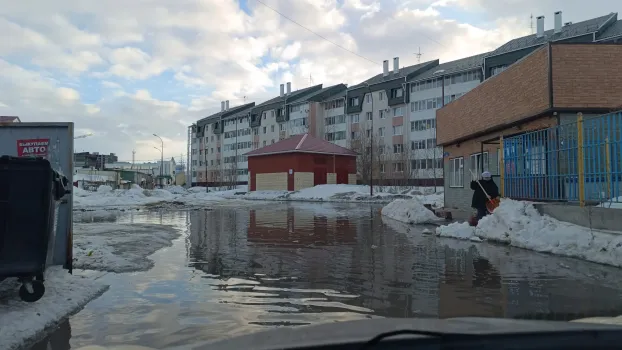 В Ханты-Мансийске затопило двор: жители добираются домой по заборам